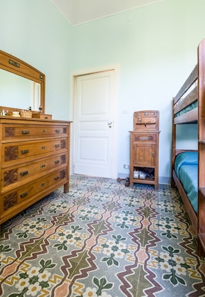 A room with a wooden dresser, a door, a small cabinet, and a bunk bed. - Villa Pietralunga, a Historic Residence (Nicosia)