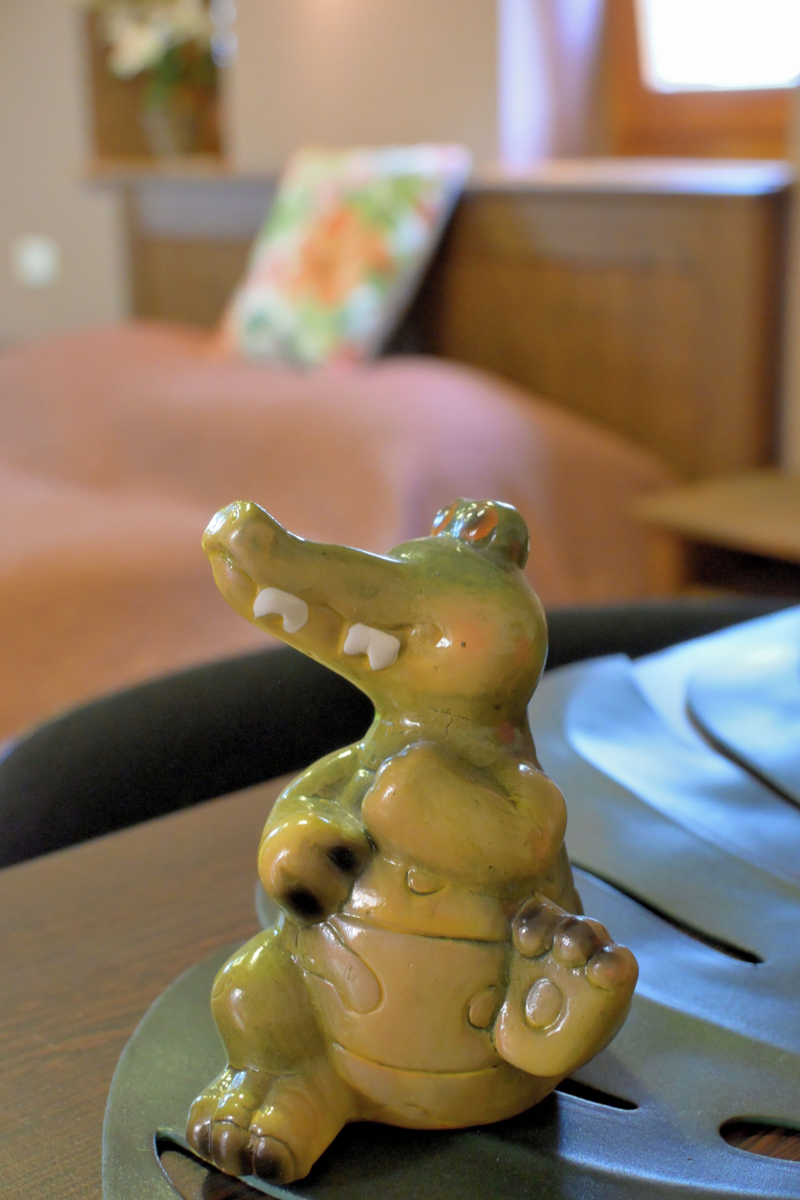 A ceramic crocodile figurine on a table.