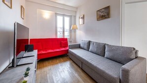 A modern living room with a red sofa, a grey sofa, a TV, and a lamp. - Luxury Apartment with Terrace - Garibaldi Station (Milan)