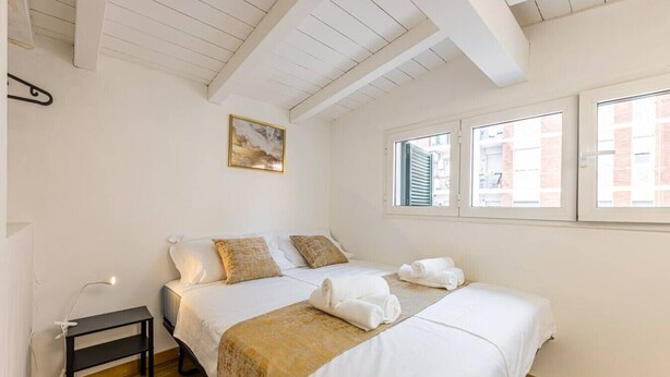 A bedroom with two beds, a small table, and a painting on the wall. - Luxury Apartment with Terrace - Garibaldi Station (Milan)