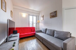 A modern living room with a red sofa, a grey sofa, a flat-screen TV, and a floor lamp. - Luxury Apartment with Terrace - Garibaldi Station (Milan)