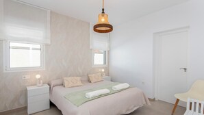 A bedroom with a bed, bedside tables, a hanging light fixture, a window, and a door. - Casa Tomodoro - Three Bedroom Villa, Sleeps 6 (Arcos de la Frontera)