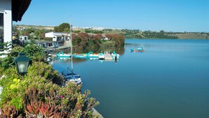 A calm lake with boats docked, a thatched-roof building, and lush greenery. - Casa Tomodoro - Three Bedroom Villa, Sleeps 6 (Arcos de la Frontera)