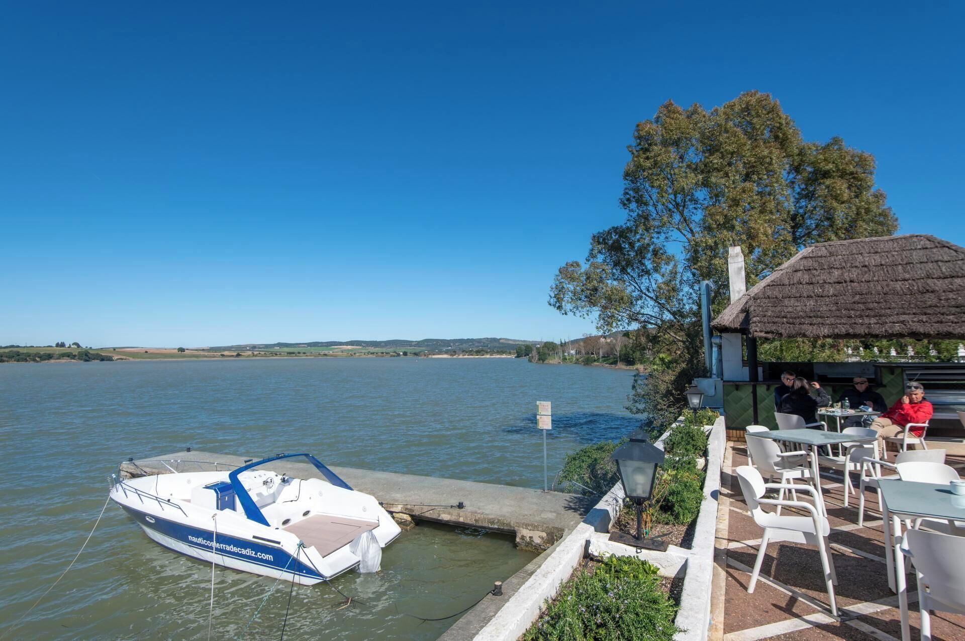 Un bateau était amarré à un quai, un restaurant proposait des tables en plein air, et on pouvait profiter d’une vue dégagée sur l’eau.
