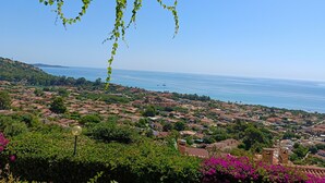 A coastal town with houses, greenery, and a clear sky. - Casa Sunshine-Sea View (Costa Rei)