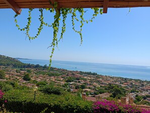 Une ville côtière avec des maisons, de la verdure et un ciel dégagé.