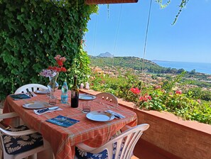 Une table dressée à l’extérieur, avec vue sur un paysage côtier.