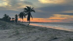 A beach with sand dunes and palm trees. - Beach house in a beachfront condominium with 3 en-suite bedrooms, Wi-Fi. (Caucaia)