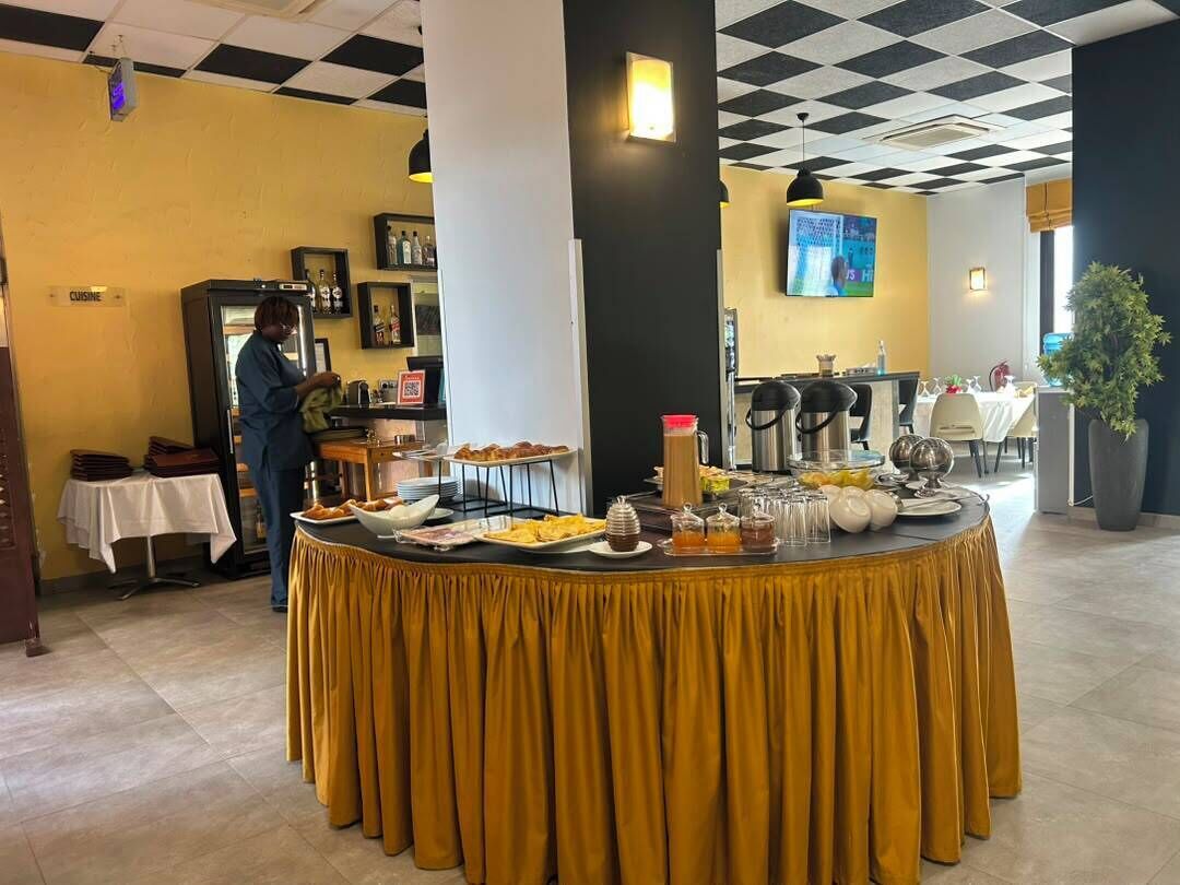 A buffet setup with various food items and a person serving.