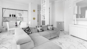 Ein modernes Wohnzimmer mit einer Eckcouch, einem Essbereich und einer Küche.