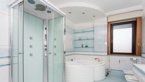 A modern bathroom with a glass-enclosed shower, a freestanding bathtub, and a vanity with a mirror. - Triple G Rooftop 105 By Dimorra  (Naples)