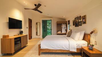 A modern bedroom with a bed, bedside tables, a TV, and a ceiling fan.