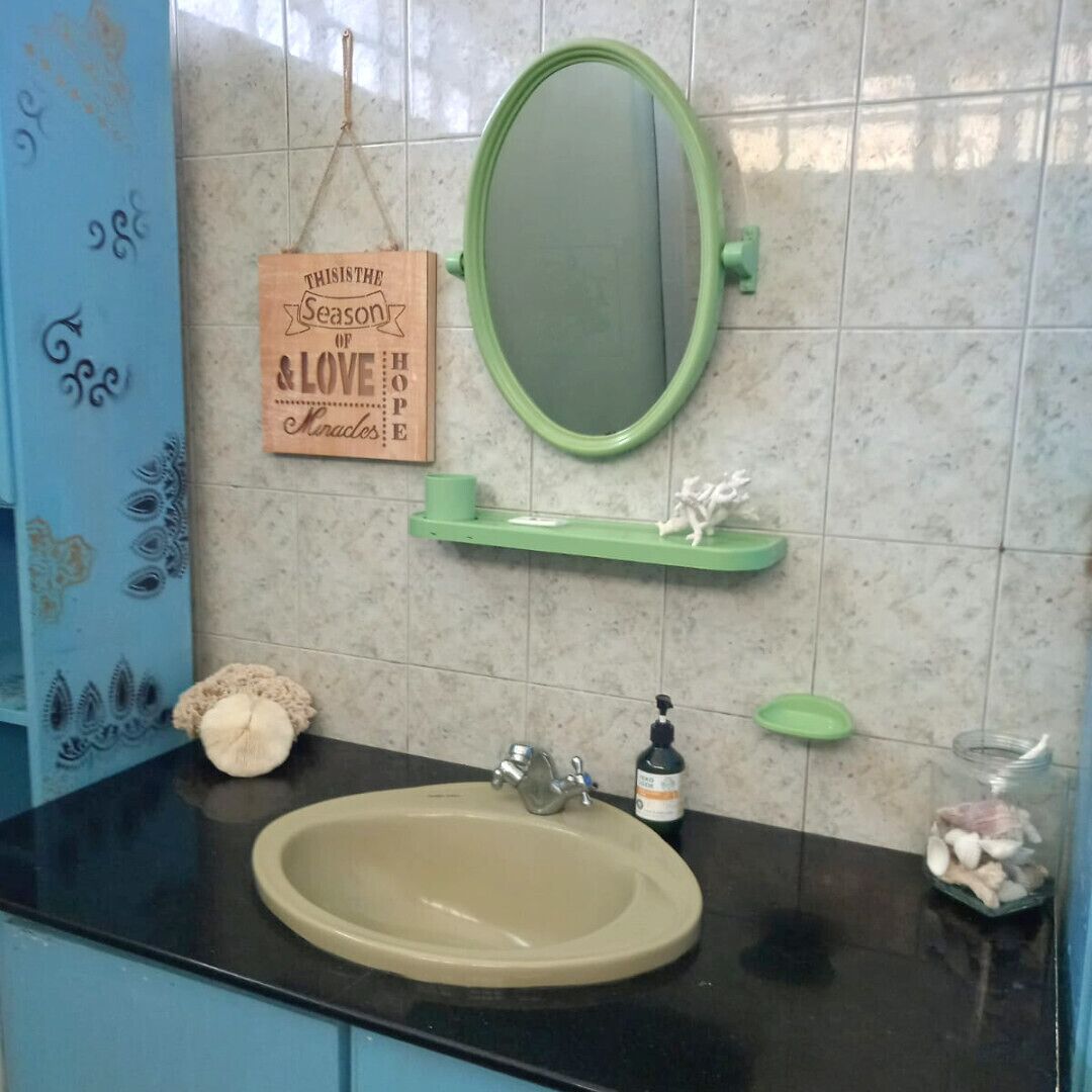 A bathroom with a sink, mirror, and decorative items.