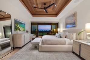 Quarto moderno com uma cama grande, uma escrivaninha, uma cadeira e vista para um campo de golfe.