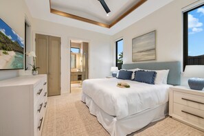 A bedroom with a large bed, bedside tables, a dresser, a painting, and a view of the outdoors. - Stunning 6BR One Ocean Estate GE6 at Mauna Lani – Island Luxury & Private Po (Kamuela)