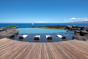 An infinity pool with lounge chairs, a wooden deck, and a view of the ocean. - Stunning 6BR One Ocean Estate GE6 at Mauna Lani – Island Luxury & Private Po (Kamuela)