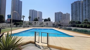 Une piscine dotée d’une terrasse carrelée, entourée d’immeubles résidentiels de grande hauteur.