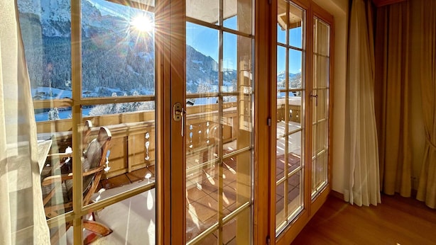 A room with large windows, a wooden balcony, and a view of snow-covered mountains. - Marvelous Luxurious Furnished Flat With Outstanding Views (Rougemont)