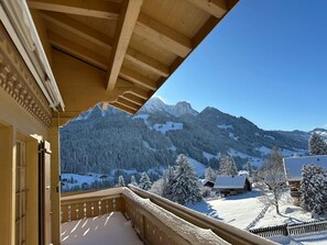 Ein Balkon mit Blick auf schneebedeckte Berge und einen klaren Himmel.
