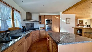 A kitchen with granite countertops, wooden cabinets, a stainless steel sink, and a built-in oven. - Marvelous Luxurious Furnished Flat With Outstanding Views (Rougemont)