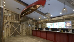 Un interno rustico con pareti in legno, una reception e lampade a sospensione.