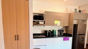 A modern kitchen with wooden cabinets, a stainless steel refrigerator, and a herringbone-patterned floor. - Carribbean Oasis Cozy 1-bedroom apartment in delightful Punta Cana with AC (Punta Cana)