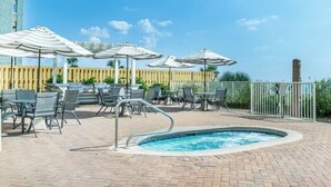 A pool area with lounge chairs and umbrellas, surrounded by a wooden fence and a metal railing. - 🏖️Twin Palms 2204 Penthouse~Gulf-Front Views 🌅 Pool~Dedicated Parking (Panama City Beach)