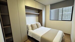 Ein Schlafzimmer mit einem Bett, einem Einbauschrank und einem Fenster.