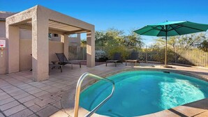 A swimming pool with a sunshade, lounge chairs, and a covered seating area. - Delightful Resort Near Santa Catalina Mountains! (Oro Valley)
