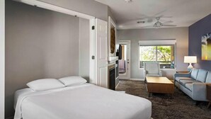 A hotel room with a bed, a desk, a sofa, a ceiling fan, and a window. - Delightful Resort Near Santa Catalina Mountains! (Oro Valley)
