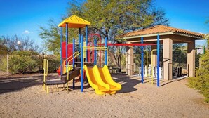 A playground with a slide, climbing structures, and a covered seating area. - Delightful Resort Near Santa Catalina Mountains! (Oro Valley)
