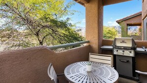 A patio with a grill, a round table, and chairs. - Delightful Resort Near Santa Catalina Mountains! (Oro Valley)