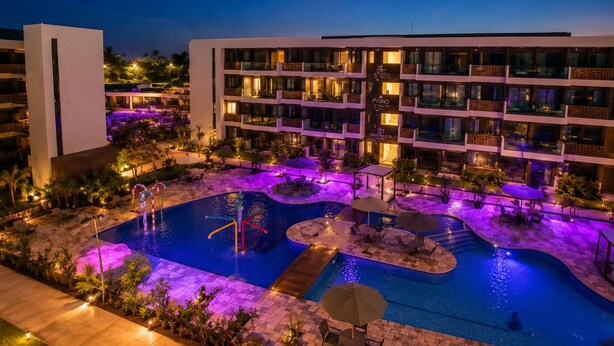 Un hôtel doté d’une piscine, de plusieurs balcons et d’espaces de détente en plein air.