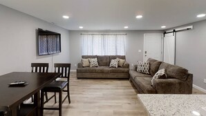 A living room with a sofa, a dining table, and chairs. - -Cheerful 3 bed home--inside COMPLETELY renovated! (Hays)