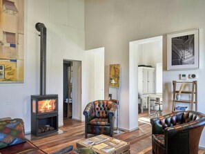 A modern living room with a fireplace, leather armchairs, and a coffee table with magazines. - Hot tub and hammam house in Montalcino (Montalcino)