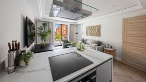 A modern kitchen with a glass hood, a built-in stove, and a dining area with a view. - The Folio Collection (London)