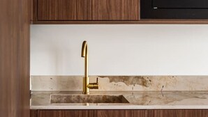 A kitchen with a wooden cabinet, a gold faucet, and a microwave. - 1-Bedroom-Louvre-Saint-Honoré-Palais-Royal-AC (Paris)