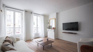 Una sala de estar con sofá, mesa de centro, televisor y chimenea.