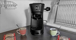 A coffee maker on a table with two mugs and two packets of coffee. - Exclusive Home Brenta: The Duomo in 10 minutes (Milano)