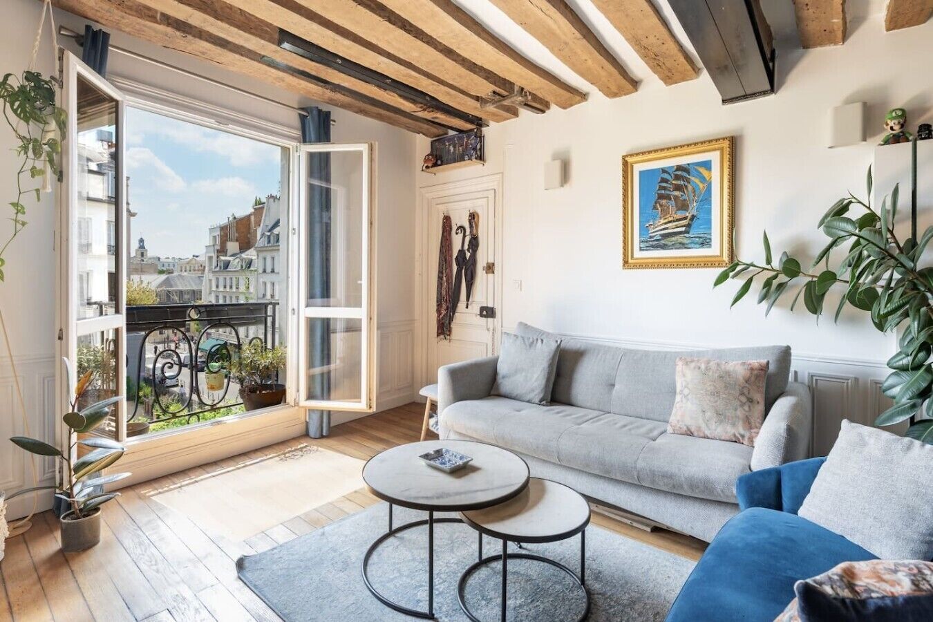 A living room with a sofa, a coffee table, and a view through a large window.