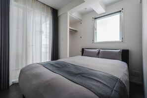 A modern hotel room with a large bed, a window with blinds, and a ceiling with skylights. - SLL Urban Suites Ebisu (Shibuya-ku)