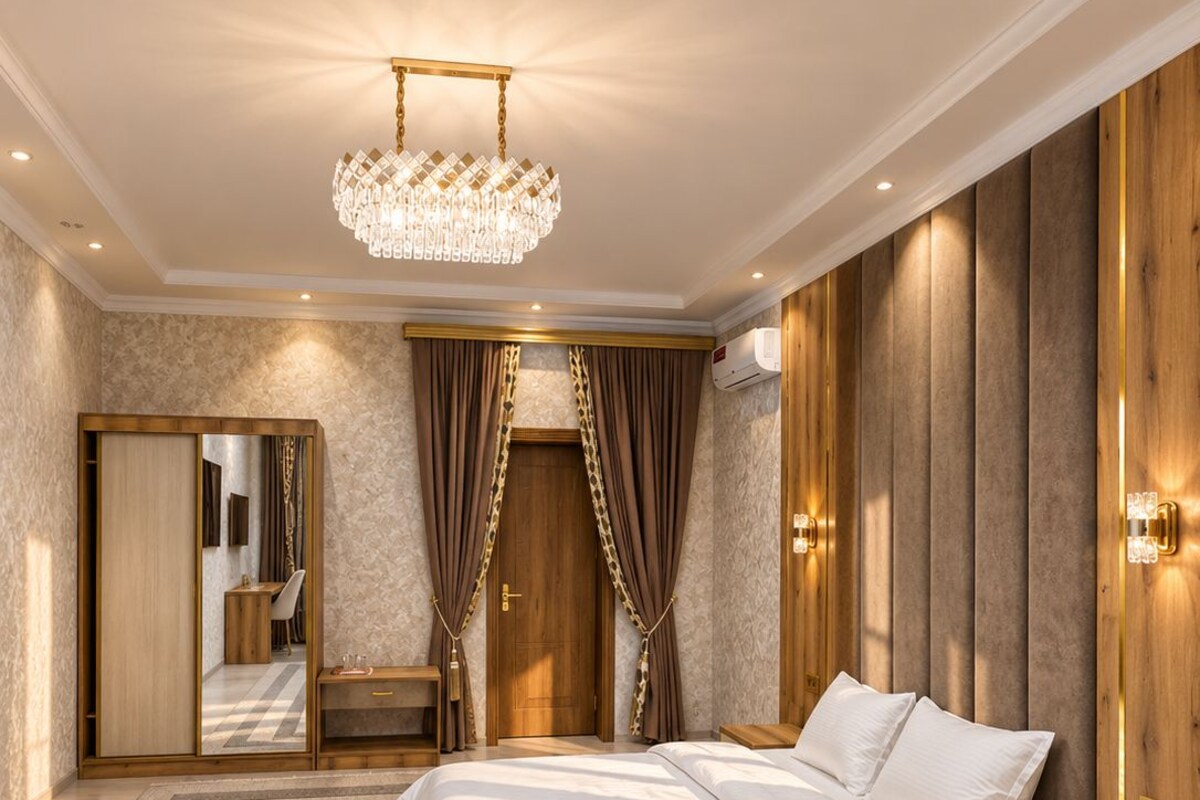 Un dormitorio con una cama grande, un armario de madera, un espejo y una araña.