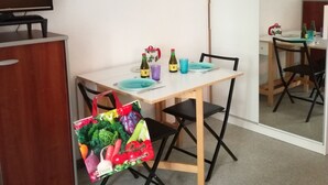 Uma área de refeições com mesa, cadeiras, televisão e espelho.