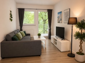 Departamento familiar, balcón, vista al patio | Área de sala de estar | Smart TV de 40 pulgadas con canales digitales y películas con cargo 