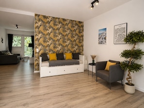 A modern living room with a sofa, a coffee table, and a potted plant. - MIILOX Apartments Chemnitz Rosenhof (Chemnitz)