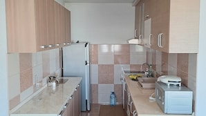 Una cocina moderna con armarios de madera, horno empotrado, microondas y lavaplatos.