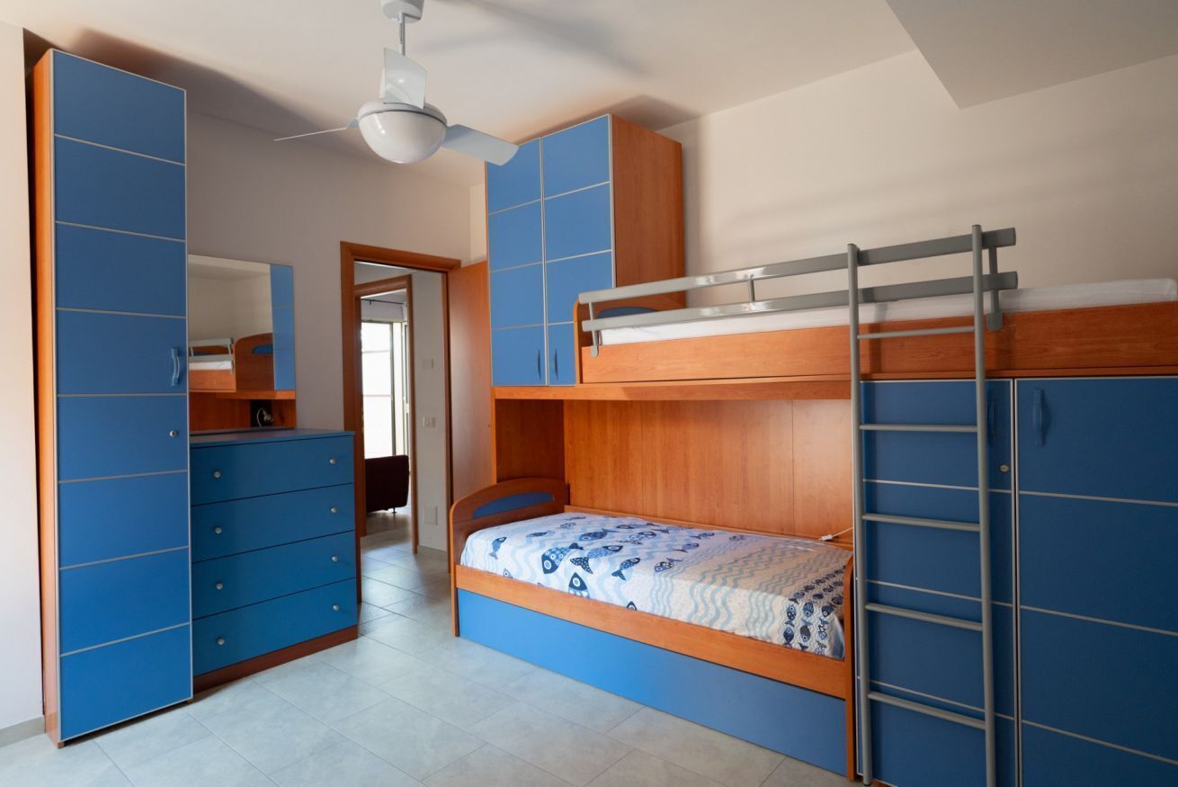 Una camera da letto con un letto a castello, un armadio e uno specchio.