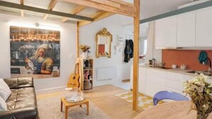 Un appartement moderne doté d’un espace de vie aménagé dans le style d’un loft, d’une cuisine et d’un coin repas.