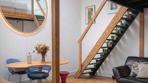 Un intérieur moderne comprenant un coin repas, un escalier et un salon.