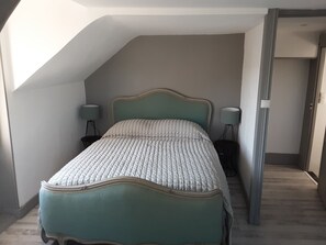 A bedroom with a bed, two bedside lamps, and a sloped ceiling. - A FAMILY-FRIENDLY LONGÈRE IN SOLOGNE, AMIDST THE CASTLES AND NEAR THE BEAUVAL ZOO (Cour-Cheverny)